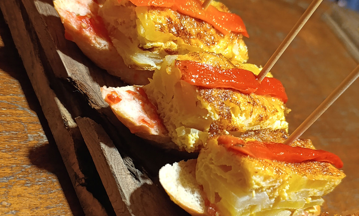 Tortilla de patata y manzana reineta, sobre pan tumaca con pimiento asado