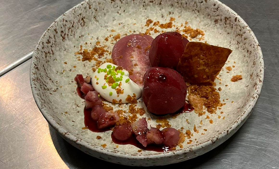 Peras al vino tinto Mencía con fresas confitadas y reducción de frambuesa